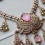 Ornate necklace with pink gemstones on a light background