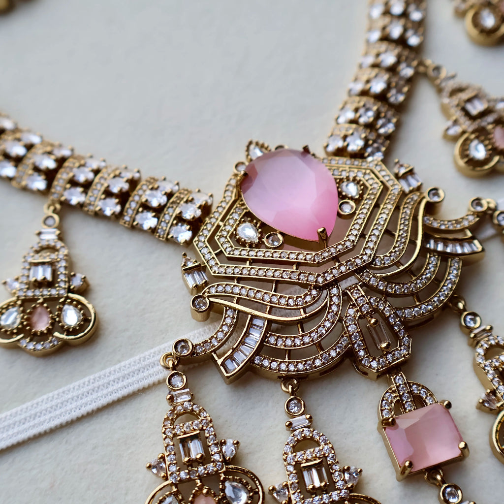 Ornate necklace with pink gemstones on a light background