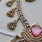 Ornate necklace with pink heart pendant and gold accents on a light background