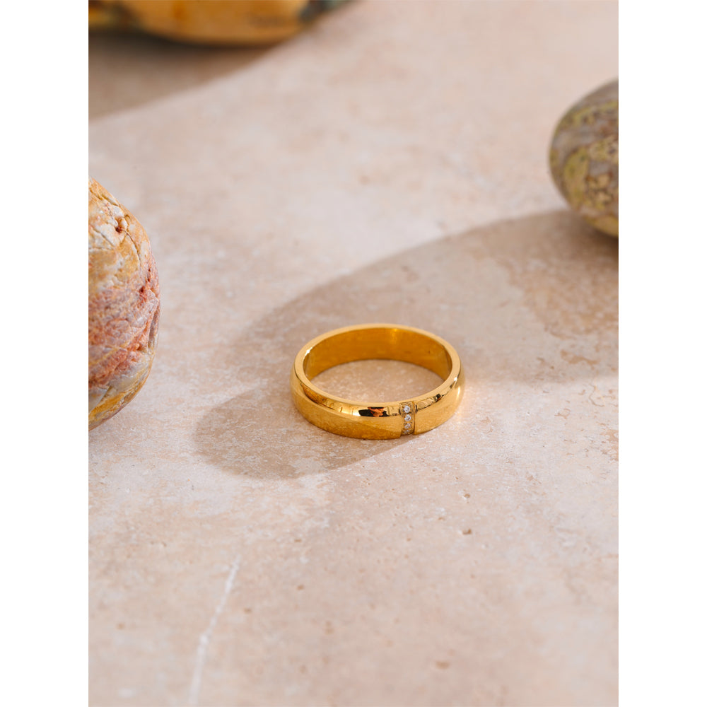 Gold ring on a textured beige surface