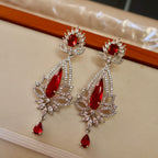 Elegant earrings with red gemstones on a neutral background