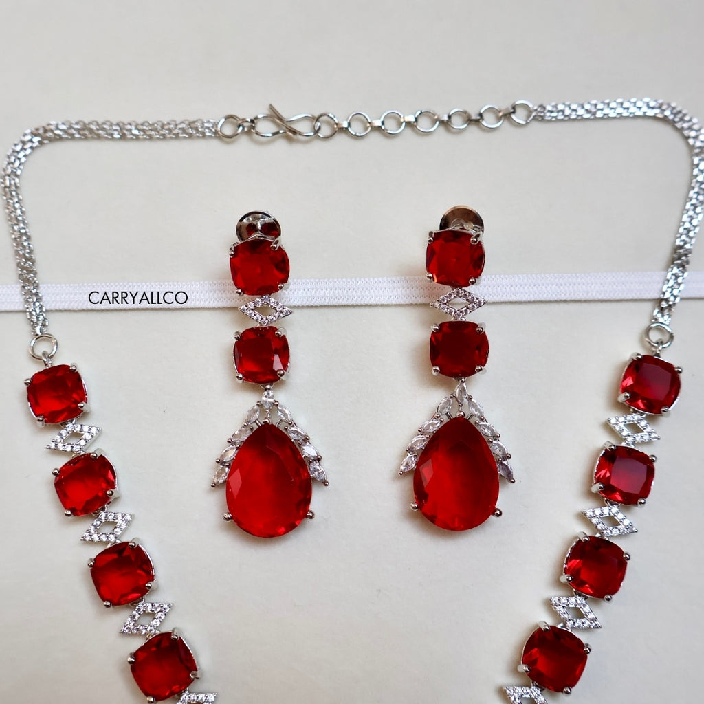 Jewelry set with red gemstones and silver accents on a white background