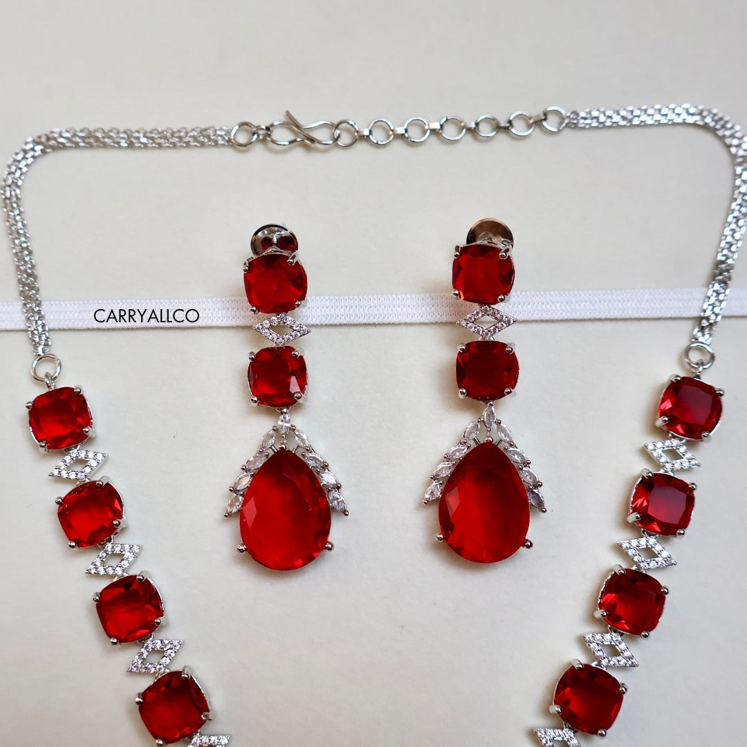 Jewelry set with red gemstones and silver accents on a white background