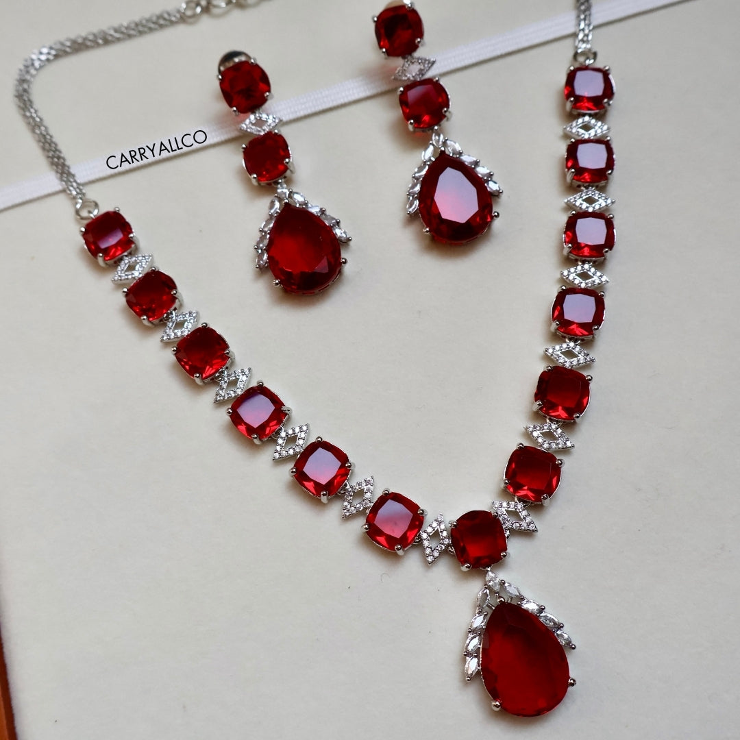 Jewelry set with red gemstones and silver accents on a white background