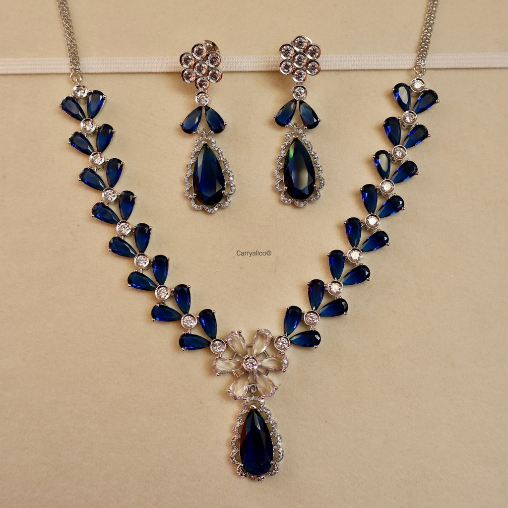 Jewelry set with blue teardrop-shaped stones on a beige background