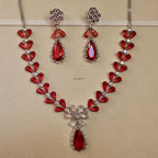 Red gemstone necklace and earrings on a beige background