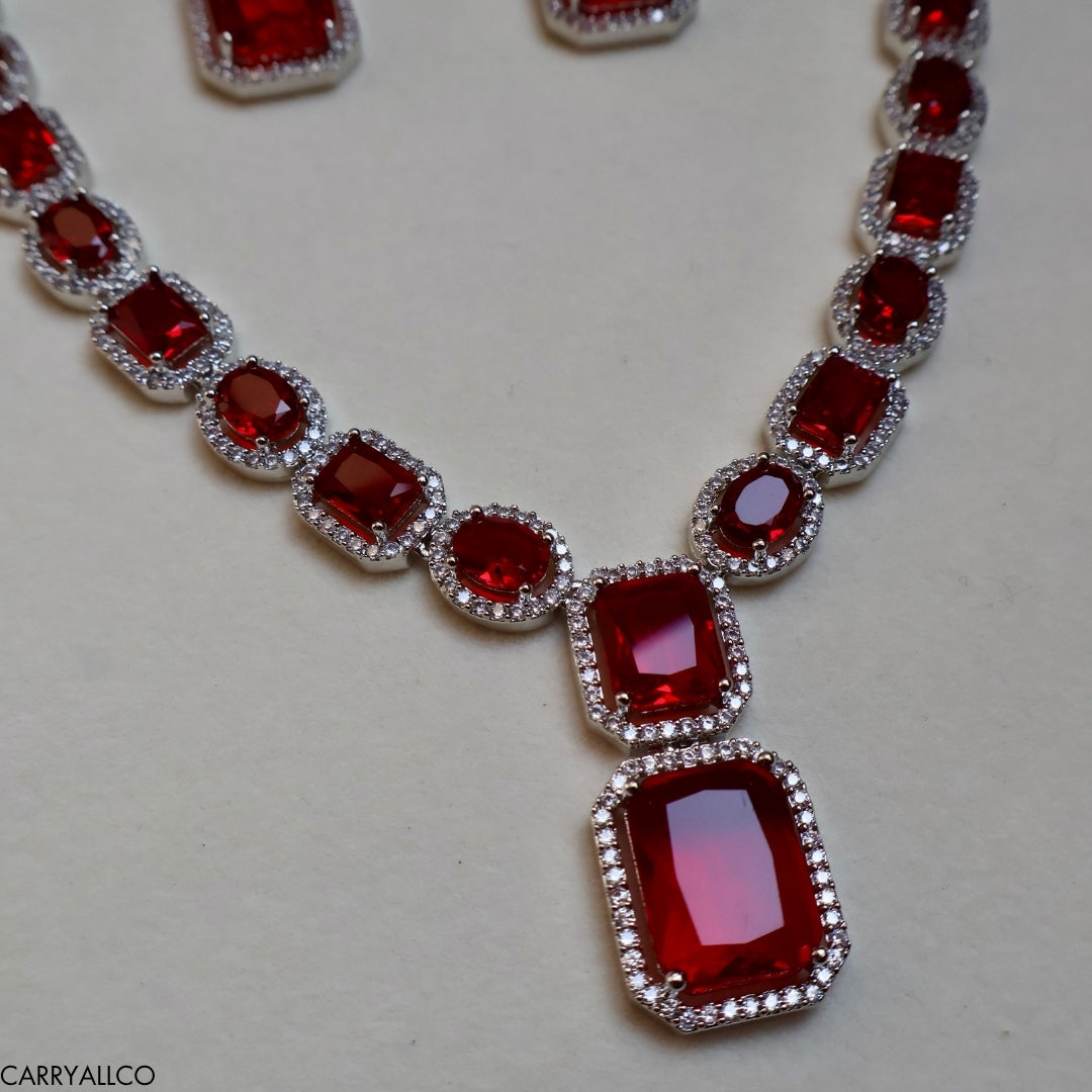 Necklace with red gemstones and silver setting on a light gray background