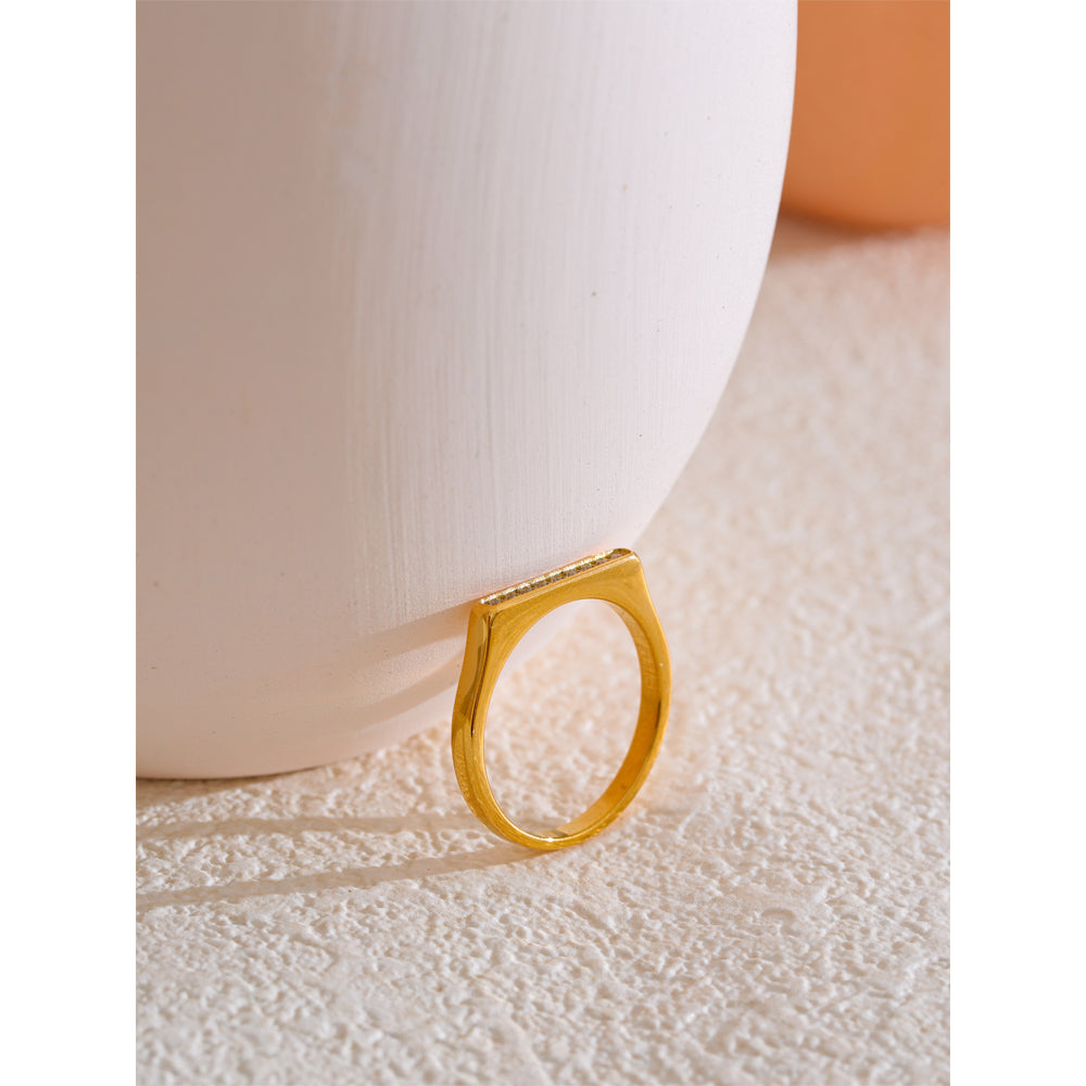 Gold ring on a textured surface with a soft background