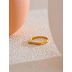 Gold ring with small diamonds on a textured surface