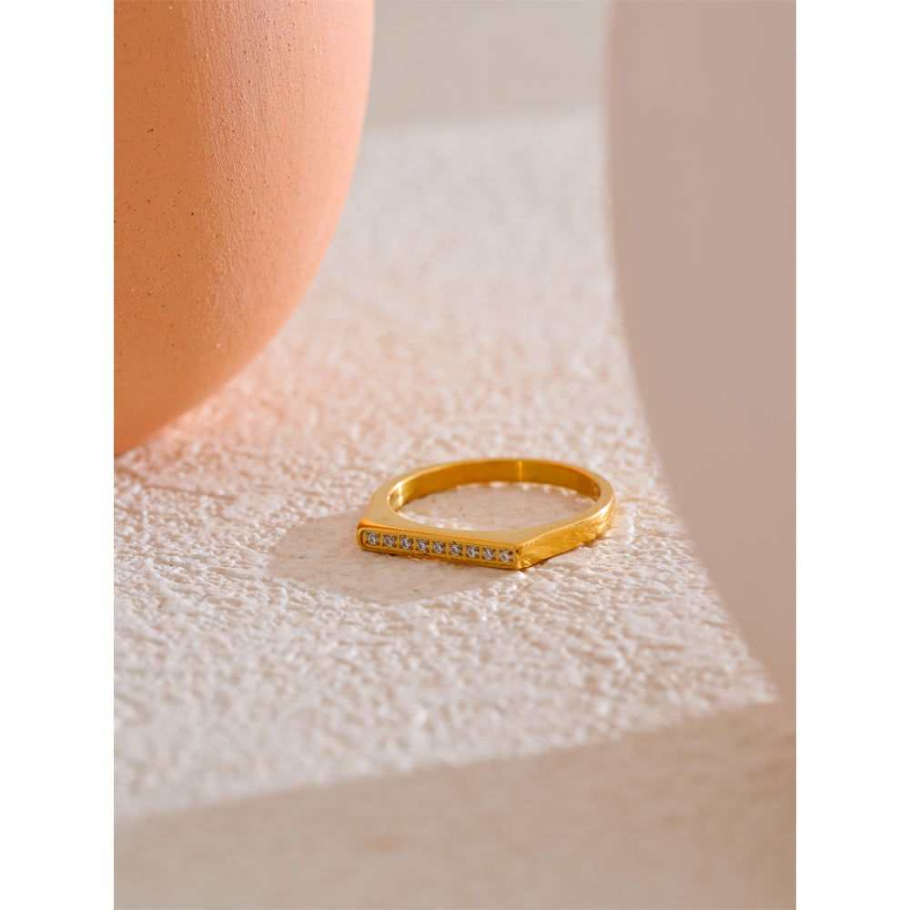 Gold ring with small diamonds on a textured surface