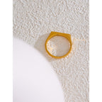 Gold ring on a textured white surface