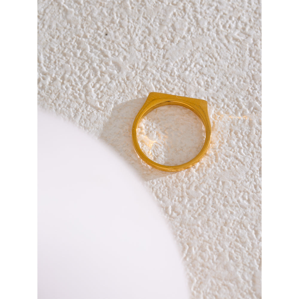 Gold ring on a textured white surface