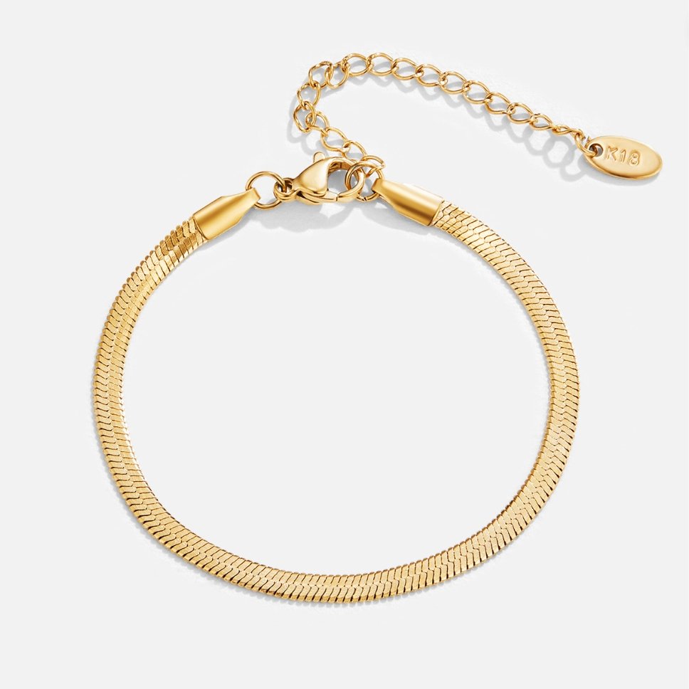 Gold bracelet on a light gray background