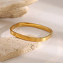 Gold bracelet on a stone surface