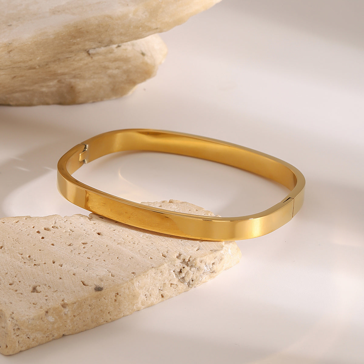 Gold bracelet on a stone surface