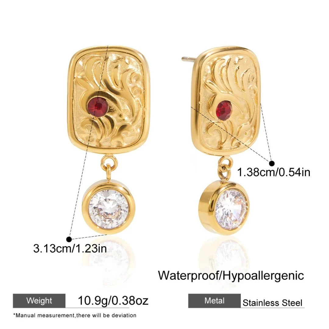Gold earrings with red gemstones and clear stones, showing measurements and material details.