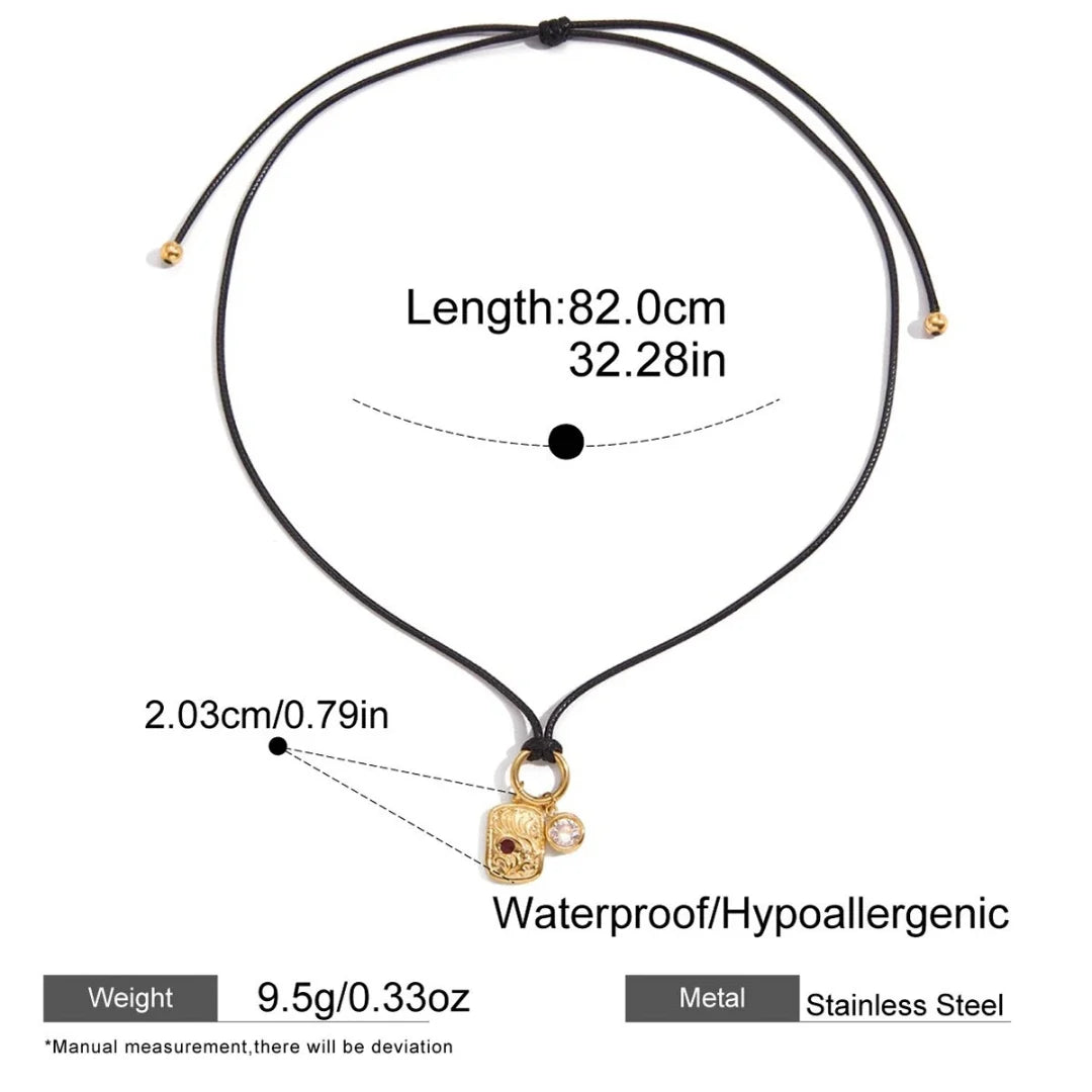 Black choker necklace with a gold charm, showing measurements and material details on a white background.