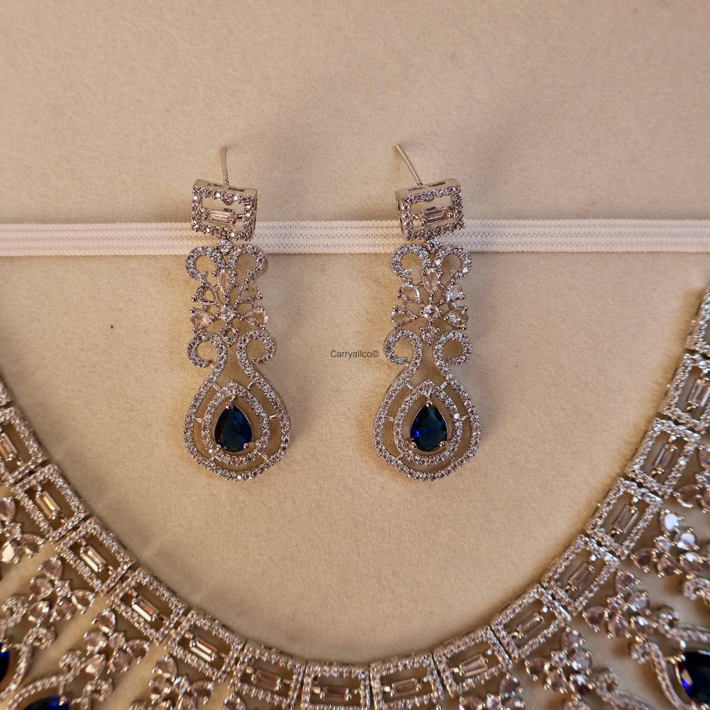 Pair of earrings with blue gemstones on a beige background