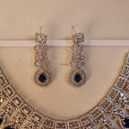 Pair of earrings with blue gemstones on a beige background