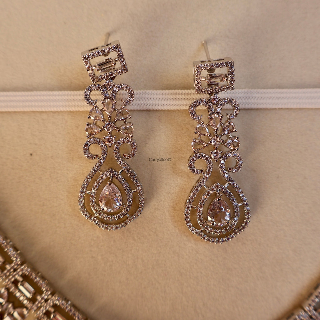 Pair of ornate earrings on a beige background