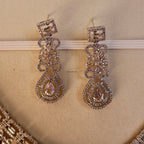 Pair of ornate earrings on a beige background