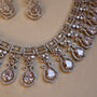 Silver necklace with teardrop-shaped pendants on a beige background