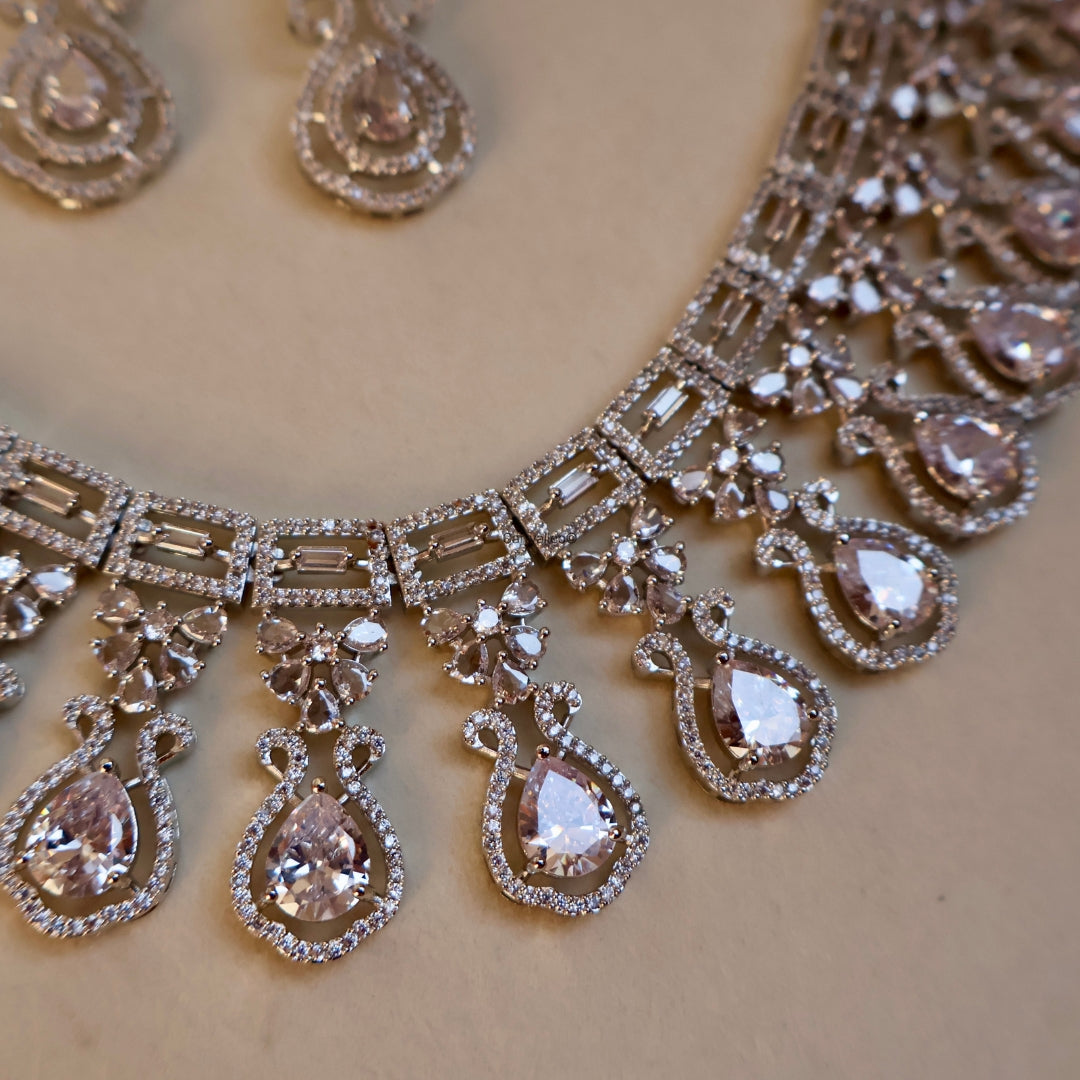 Silver necklace with teardrop-shaped pendants on a beige background